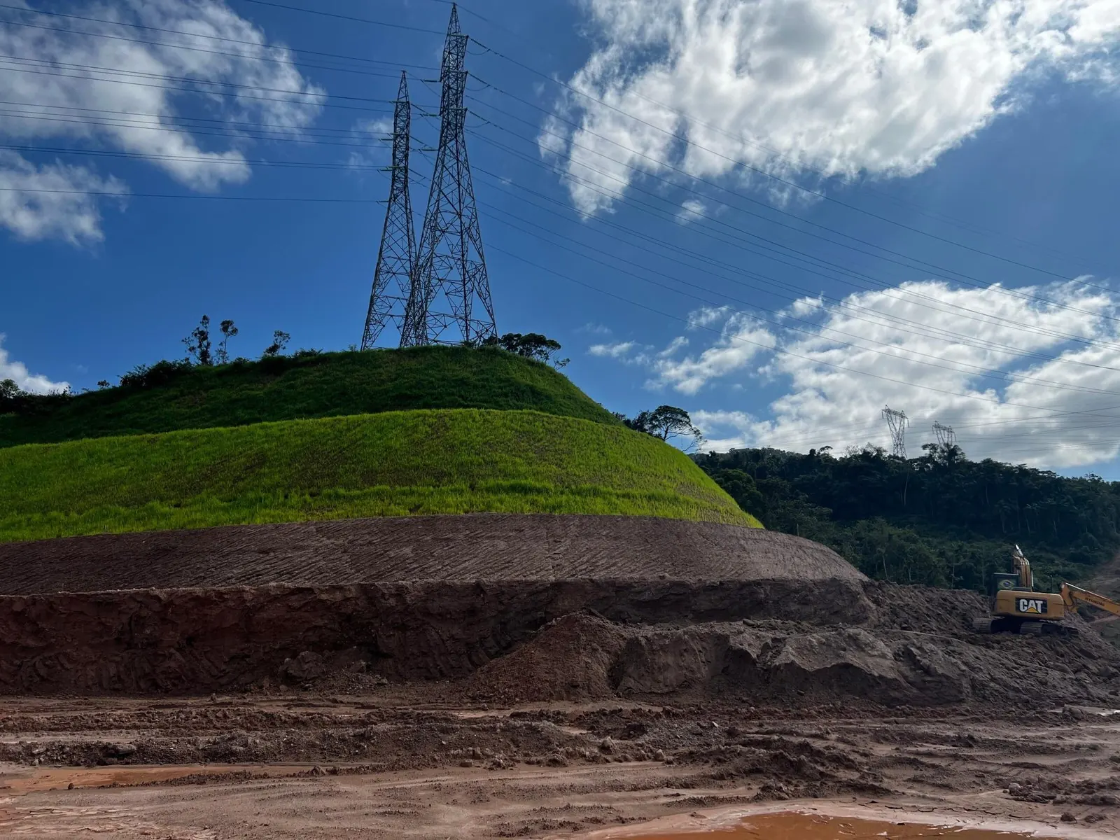 Torre de linha de transmissão sobre encosta com talude revegetado